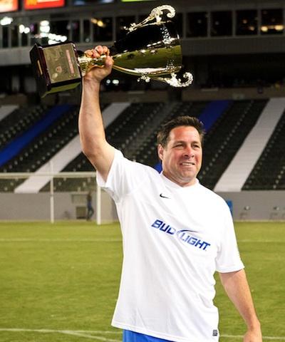 Paul Caligiuri holds up the 2012 Legends Game trophy