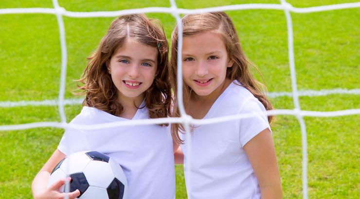 Girl Soccer Players behind Net