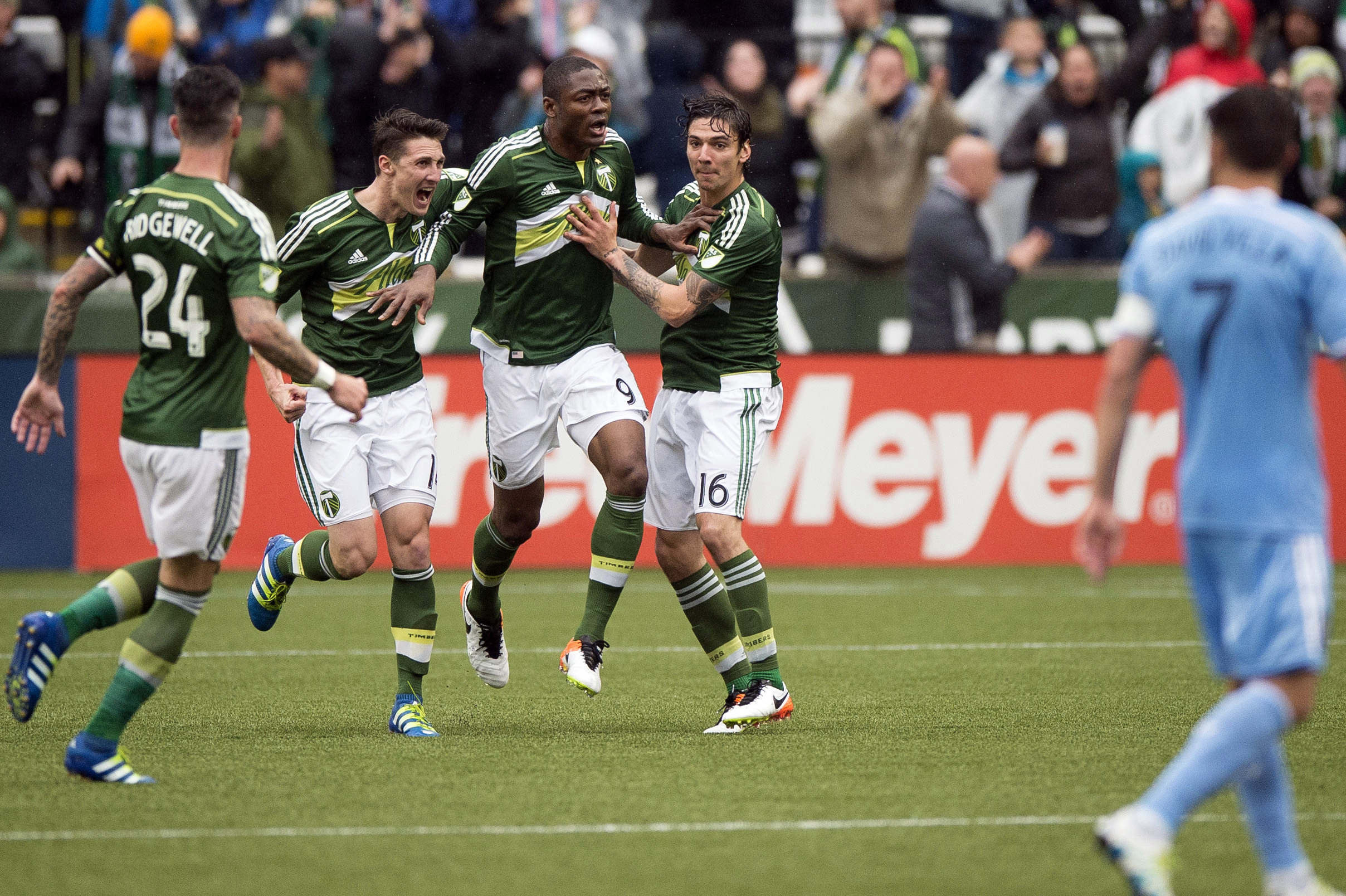May 15, 2016; Portland, OR, USA; Portland Timbers forward Fanendo Adi (9) celebrates with teammates midfielder Ben Zemanski (14) and defender Zarek Valentin (16) during the second half in a game against New York City FC at Providence Park. New York FC won 2-1. Mandatory Credit: Troy Wayrynen-USA TODAY Sports